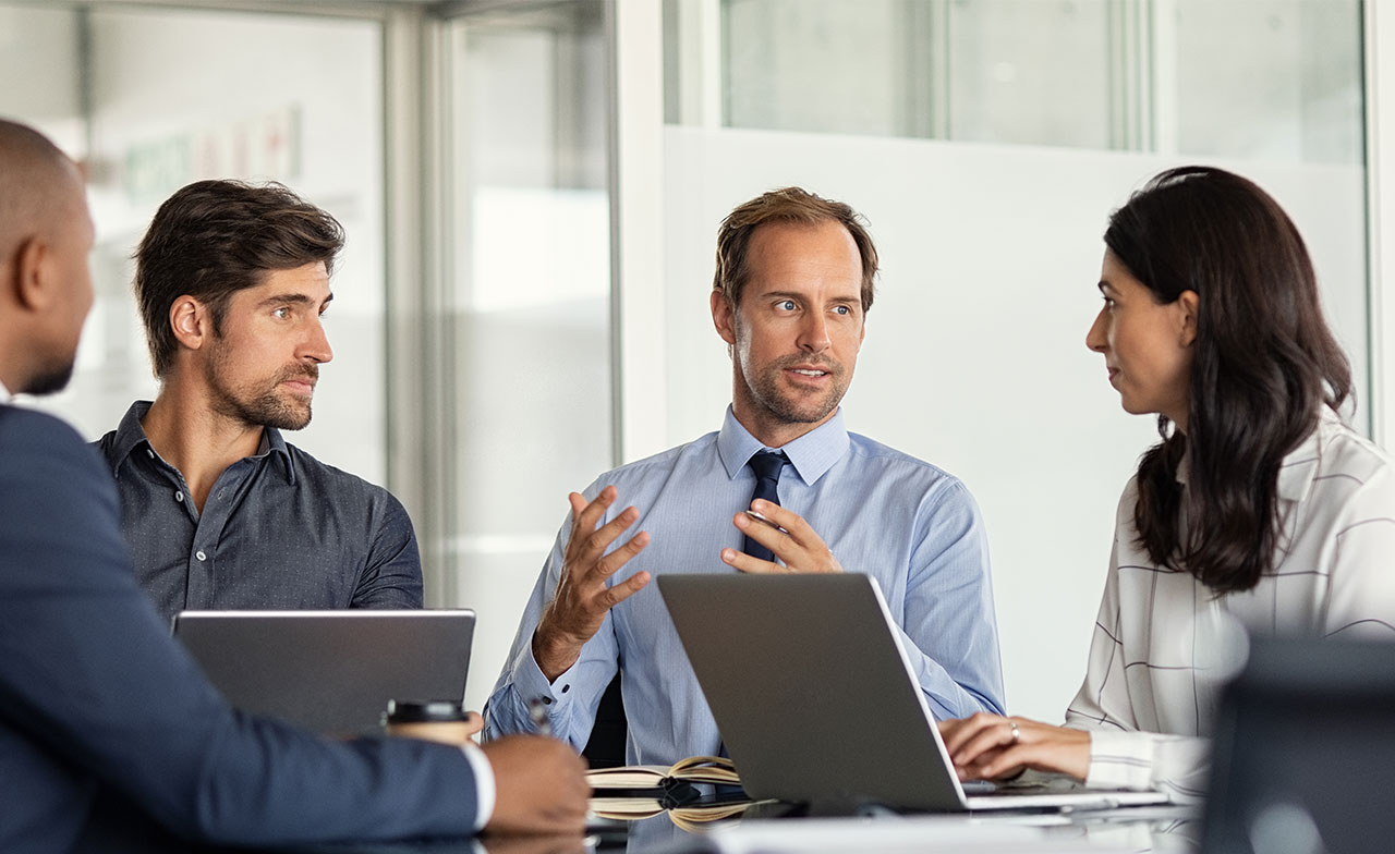 Consultants discutant dans un bureau avec des ordinateurs portables