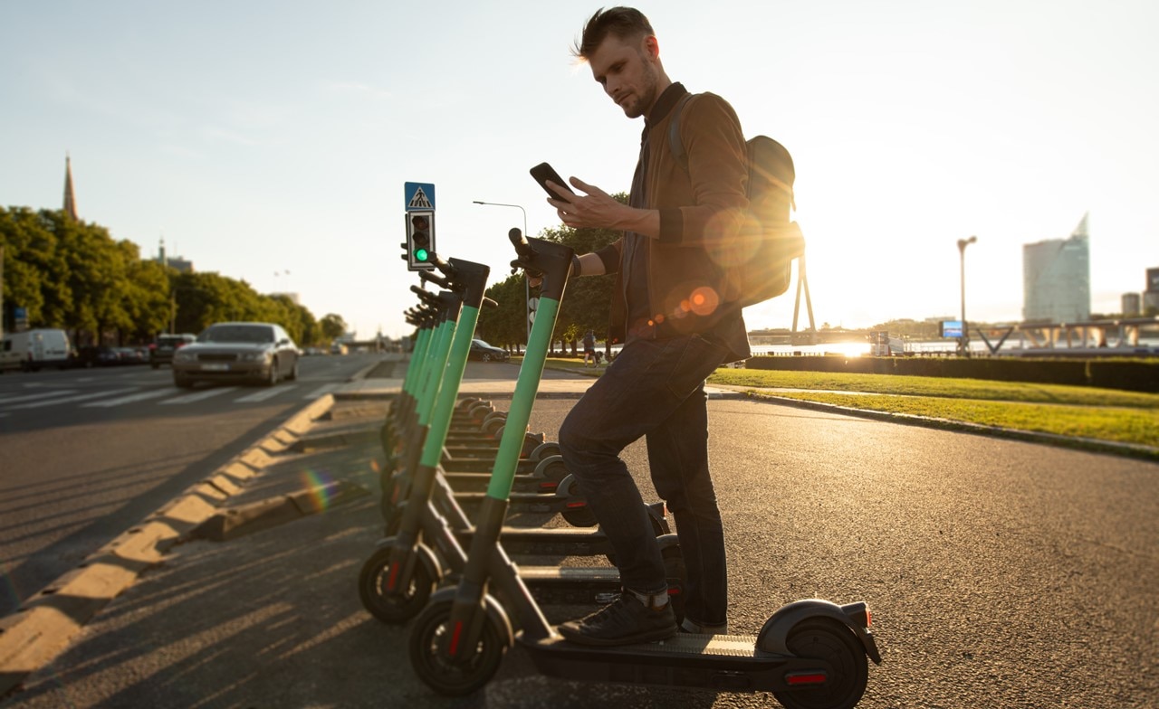 man unlocks e scooter with mobile phone