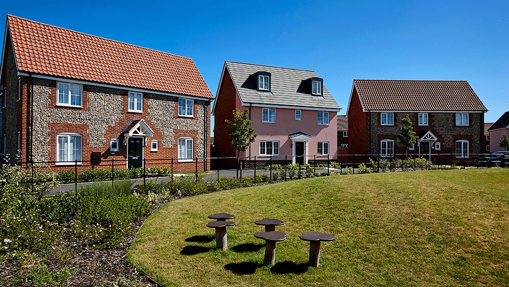 3 houses in a row surrounding grass field