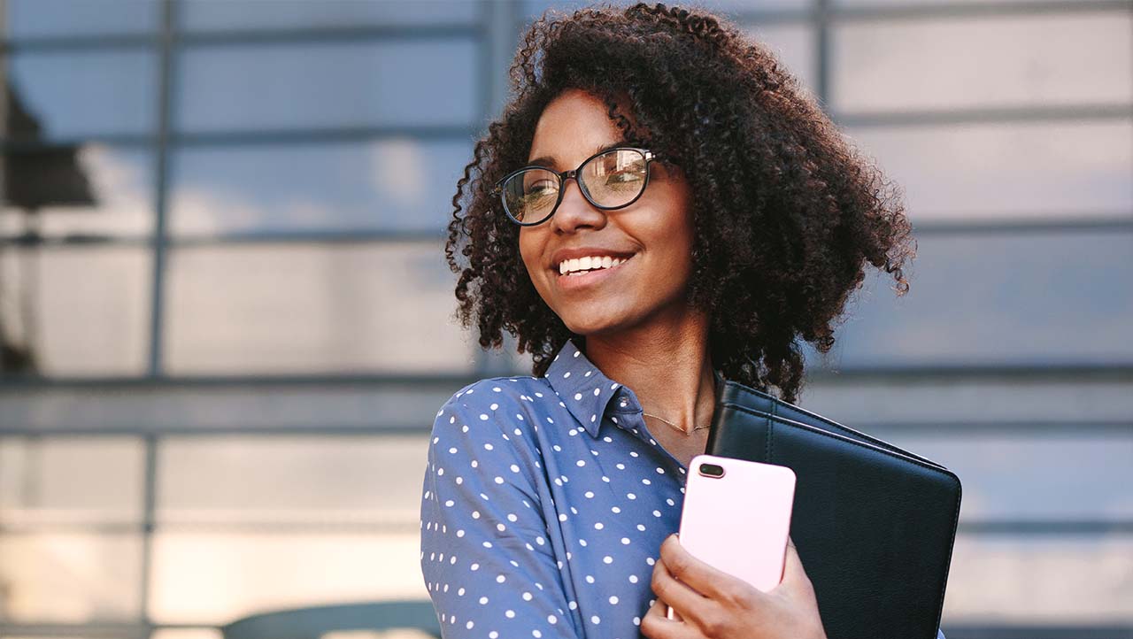 young female professional holding foler outside office