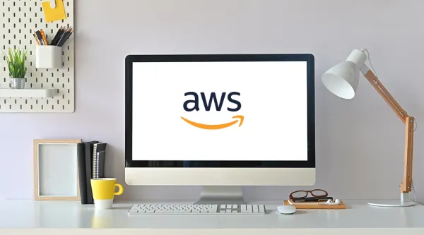 Minimalist and modern desk set up with computer monitor displaying AWS logo 