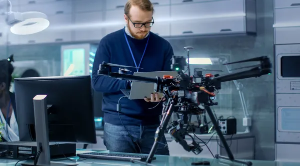 IT professional working on drone with mounted machine vision cameras