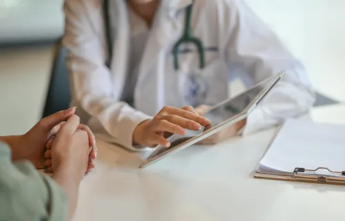 Le docteur montre les données du patient sur une tablette.