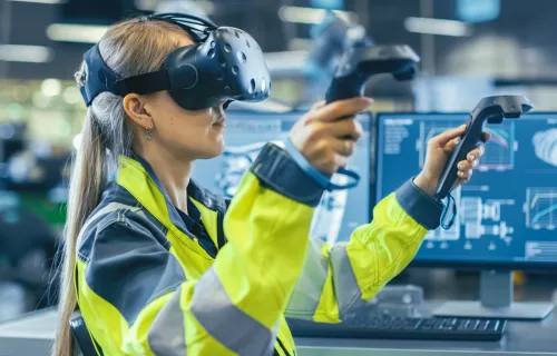 Ingénieur industriel portant un casque de réalité virtuelle et tenant des contrôleurs