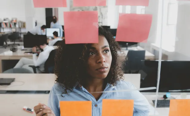 Woman looking at glass with post its on it