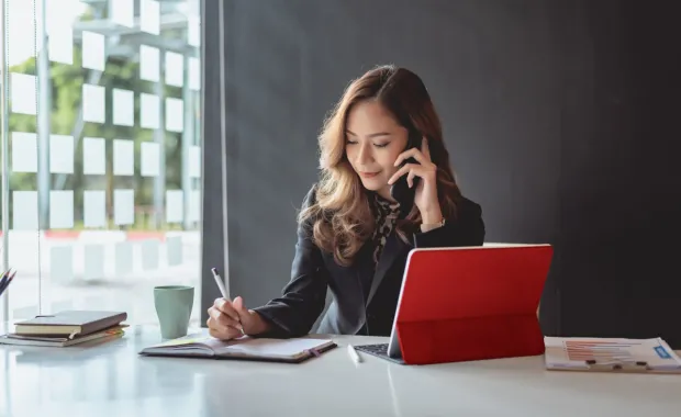 Businesswoman talking on a mobile phone at a desk