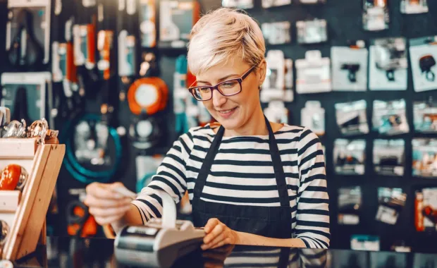 female worker short blonde hair using cash register in bicycle store