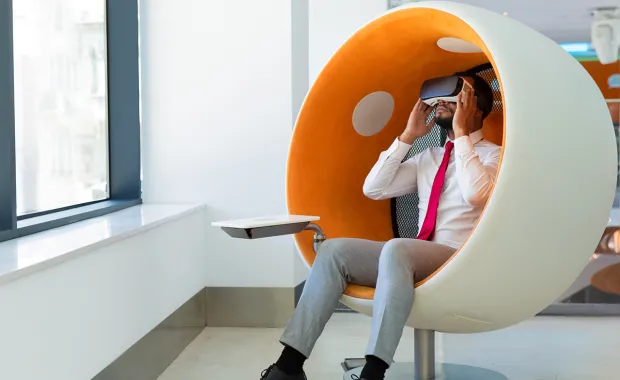 Person in VR headset in orange and white chair